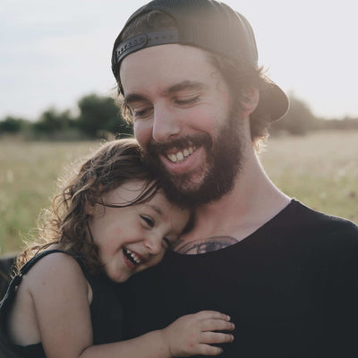 Man and child hugging in a field with a blurred background