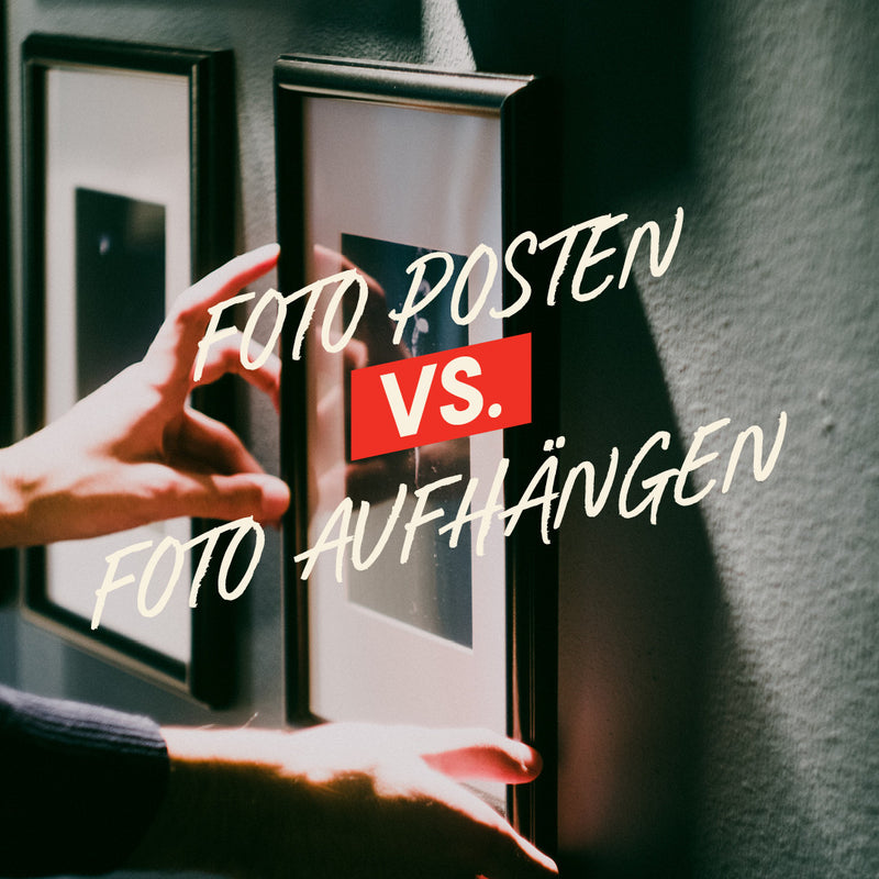 Two hands holding framed pictures with text 'FOTO POSTEN VS. FOTO AUHÄNGEN' on a wall.